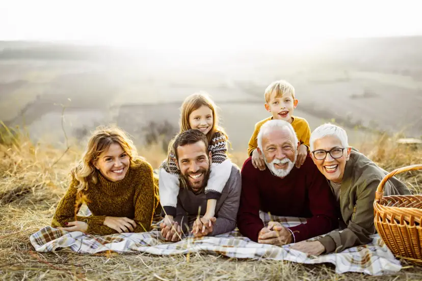 Smiling multi-generational family relaxing together on a blanket outdoors